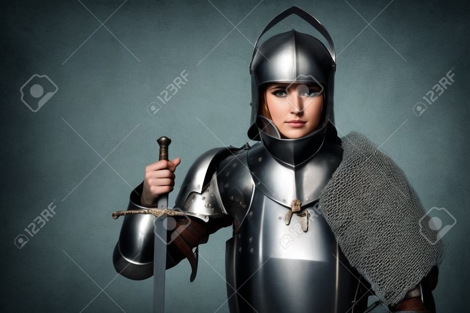 Retrato de um cavaleiro medieval do sexo feminino na armadura sobre o fundo cinzento.