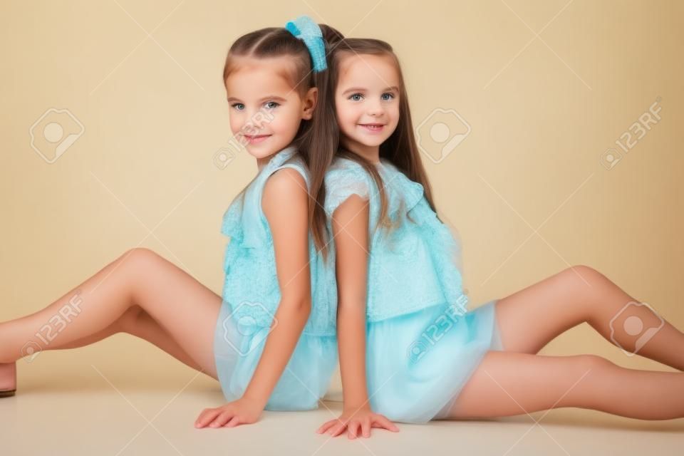 Retrato de dos hermanas niñas posando en el estudio. Aislado en blanco.
