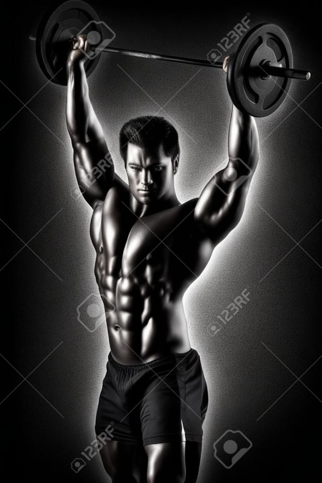 Ritratto di un bel bodybuilder muscolare posano su sfondo nero.
