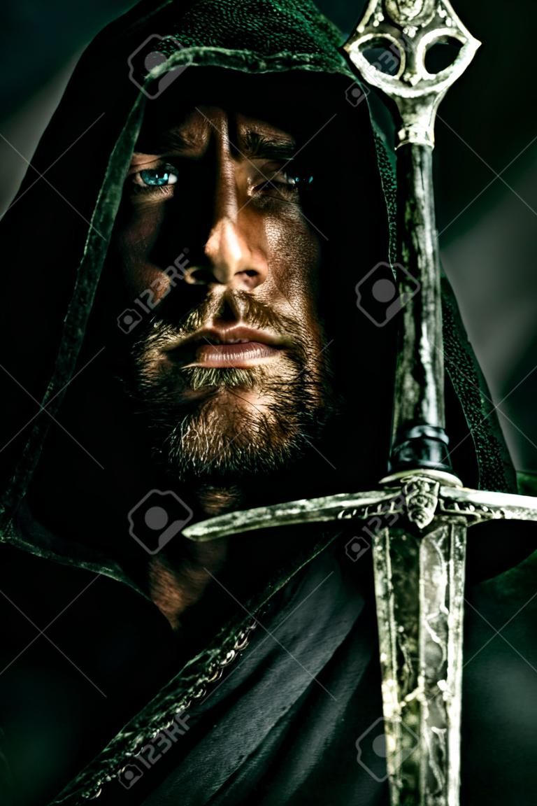 Портрет мужественный воин странник в черном плаще и мечом в руках