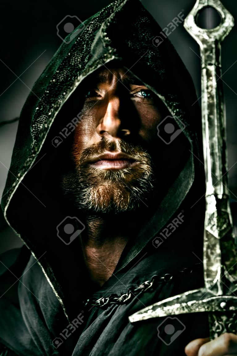 Porträt einer mutigen Krieger Wanderer in einem schwarzen Mantel und Schwert in der Hand