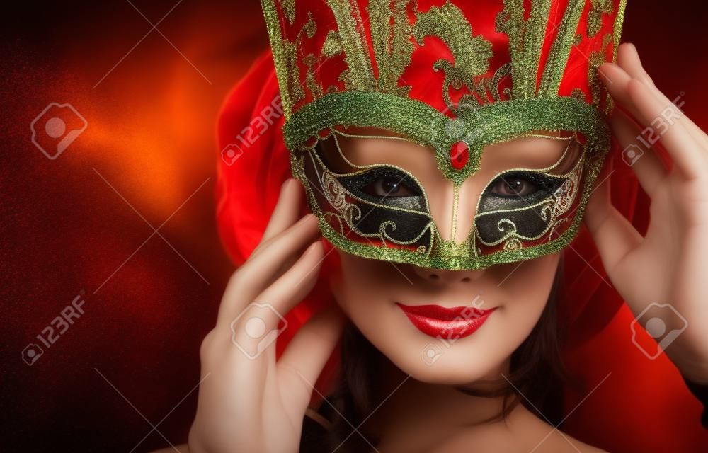 Beautiful young woman in carnival mask. Masquerade. Dark background.