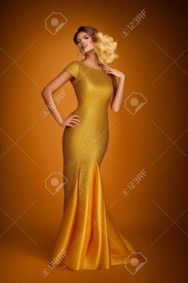 Fashion shot van een prachtige vrouw in luxe gouden jurk. Volledige lengte portret.