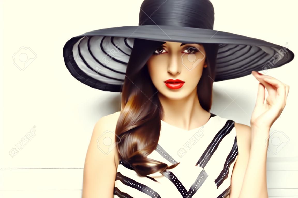 Retrato de una hermosa mujer elegante en elegante sombrero de ala ancha