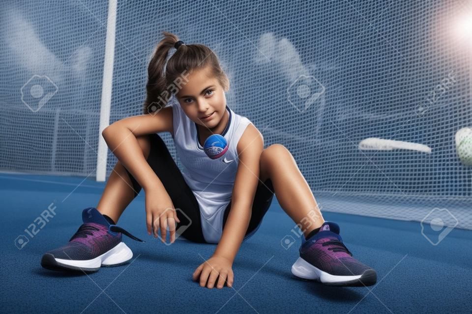 운동장에서 포즈를 취하는 스포티한 십대 소녀의 전체 길이 초상화. 스포츠 패션, 활동적인 라이프 스타일.