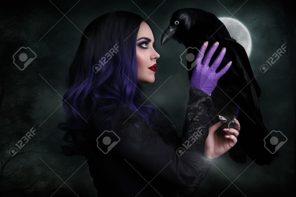 Uma bruxa de chapéu e vestido com um corvo. Halloween. Celebração.