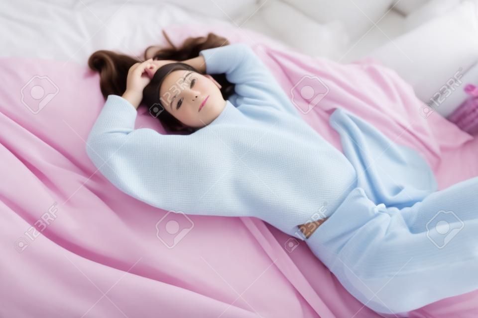 Portret nastolatka Ładna dziewczyna leżąc na łóżku w sypialni. Piękno, moda.