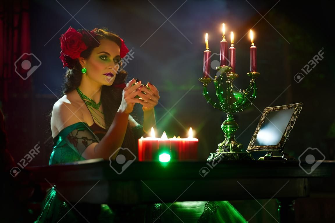 Bewitching fortune teller woman reading future on magical crystal ball.