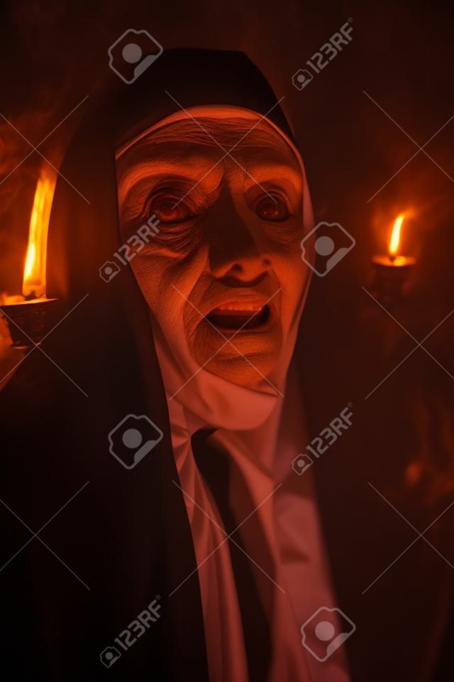 Halloween and Horrors. Portrait of a terrible cursed nun in the light of hellfire.