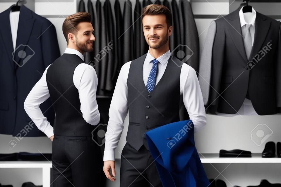 Portrait de deux beaux hommes respectables en costumes classiques élégants dans un magasin de vêtements pour hommes haut de gamme. Style d'affaires. La mode masculine.