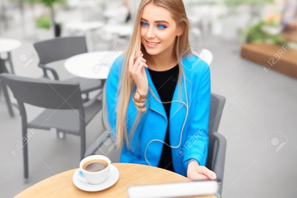 gyönyörű kék ​​szemű lány egy kávéházban tabletta