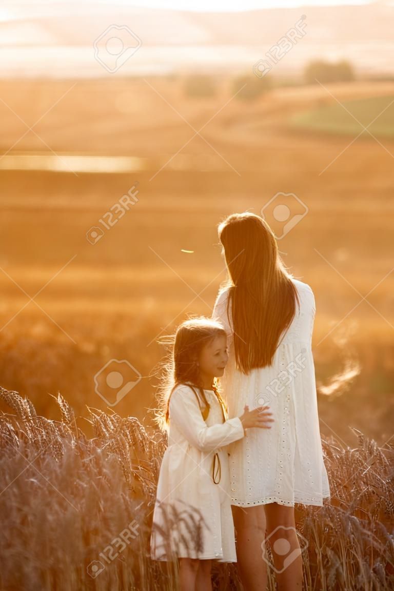 Moeder met dochter in een tarweveld