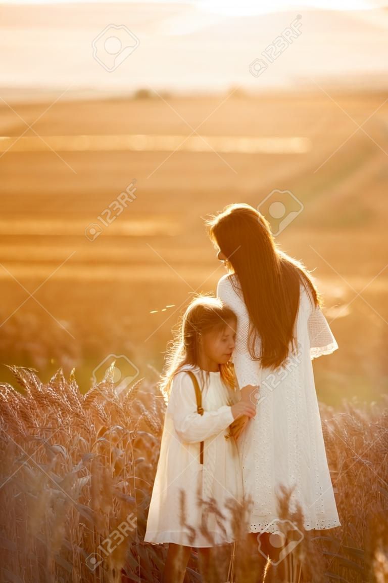 Moeder met dochter in een tarweveld