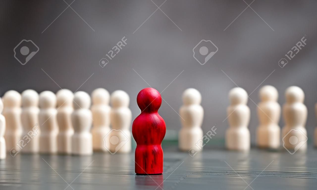 Drewniana figura stojąca przed zespołem, aby pokazać koncepcję wpływu i wzmocnienia przywództwa biznesowego dla zespołu liderów, zwycięzcy konkursu i lidera z wpływami