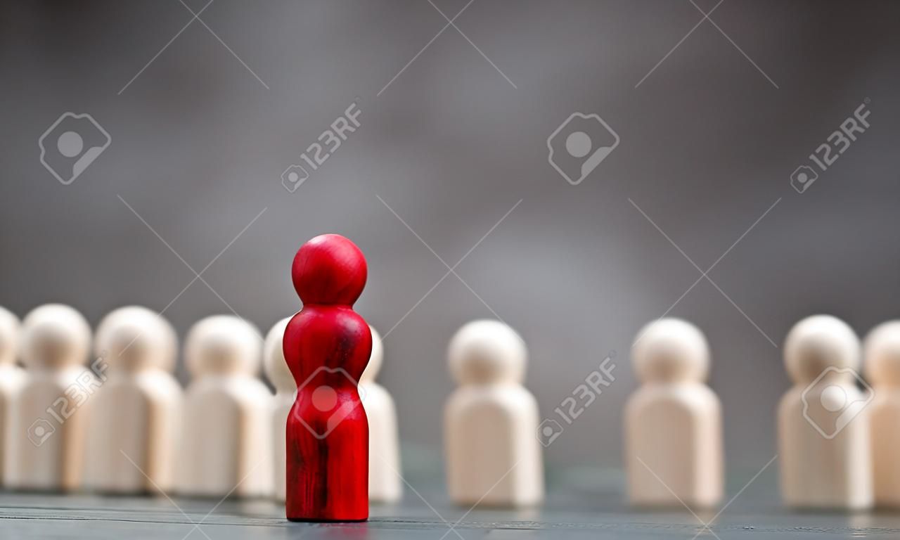 Wooden figure standing in front of the team to show influence and empowerment. Concept of business leadership for leader team, successful competition winner and Leader with influence