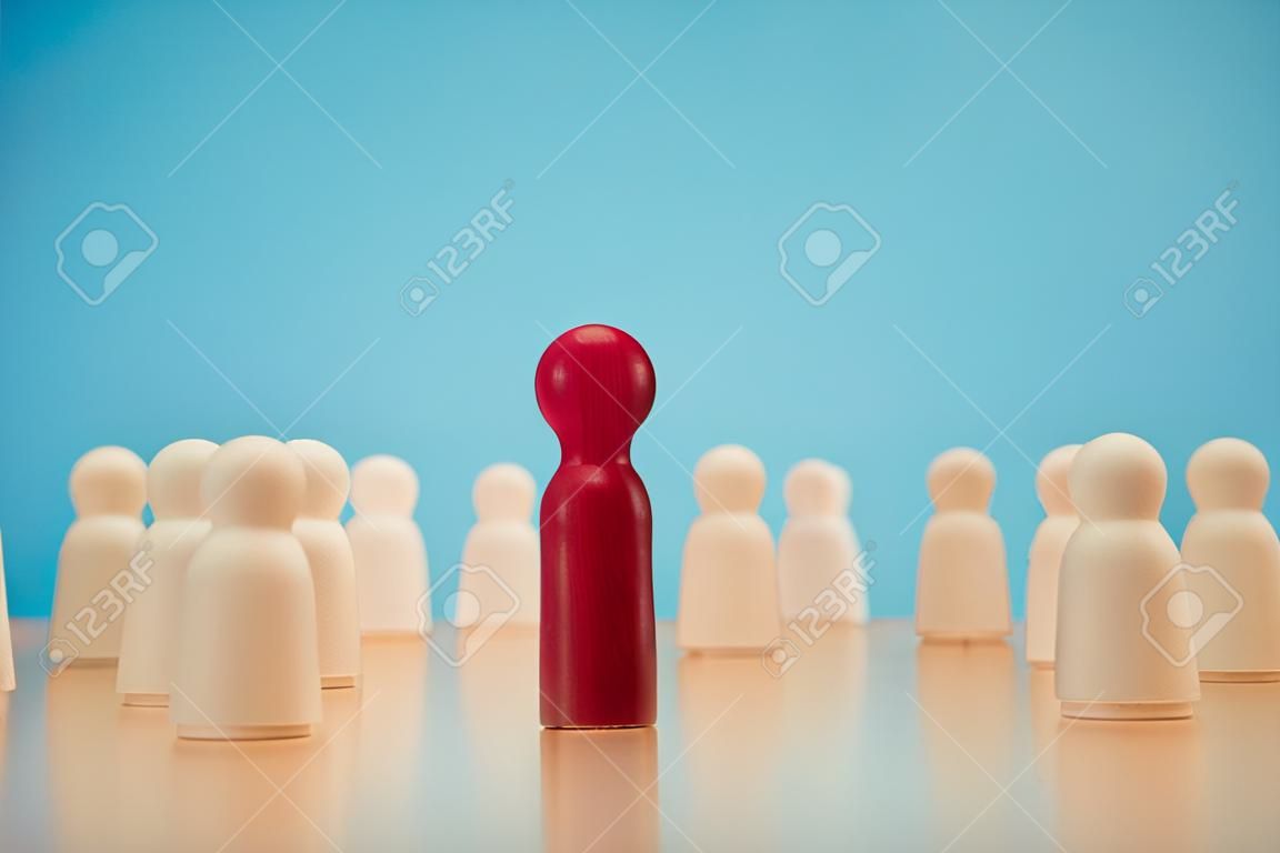 Drewniana figurka stojąca z drużyną, aby pokazać wpływ i siłę. koncepcja przywództwa biznesowego dla zespołu liderów, zwycięzcy konkursu i lidera z wpływami