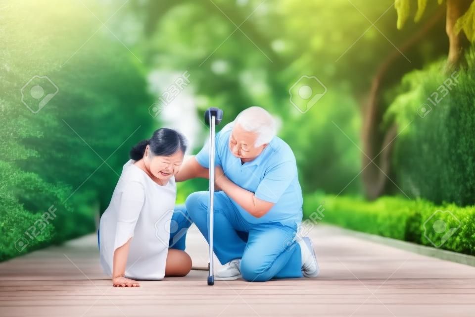 Azjatycka starsza kobieta upadła na leżącą podłogę w domu po tym, jak potknęła się na progu i płakała z bólu, a jej mąż przyszedł pomóc. koncepcja starego ubezpieczenia i opieki zdrowotnej w podeszłym wieku