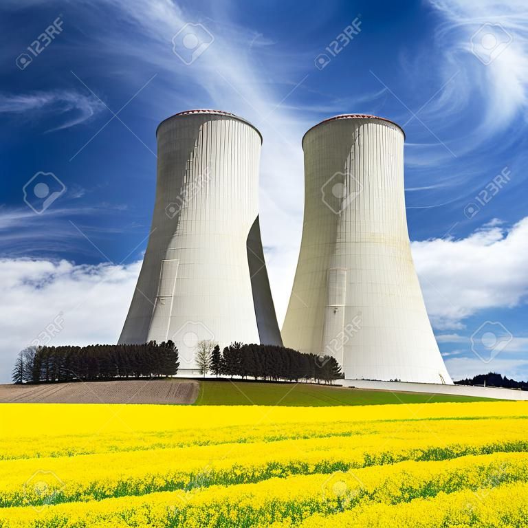 Kerncentrale Dukovany, koeltoren met gouden bloeiveld van koolzaad, canola of koolzaad-Tsjechië - twee mogelijkheden voor de productie van energie
