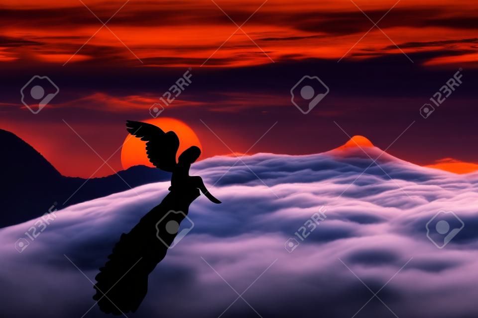 낙원 일몰에 대하여 절벽에 서 긴 날개를 가진 외로운 타락한 천사의 실루엣입니다. 산에서 구름을 통해 황혼 하늘입니다. 하늘 풍경 장면 화면 보호기