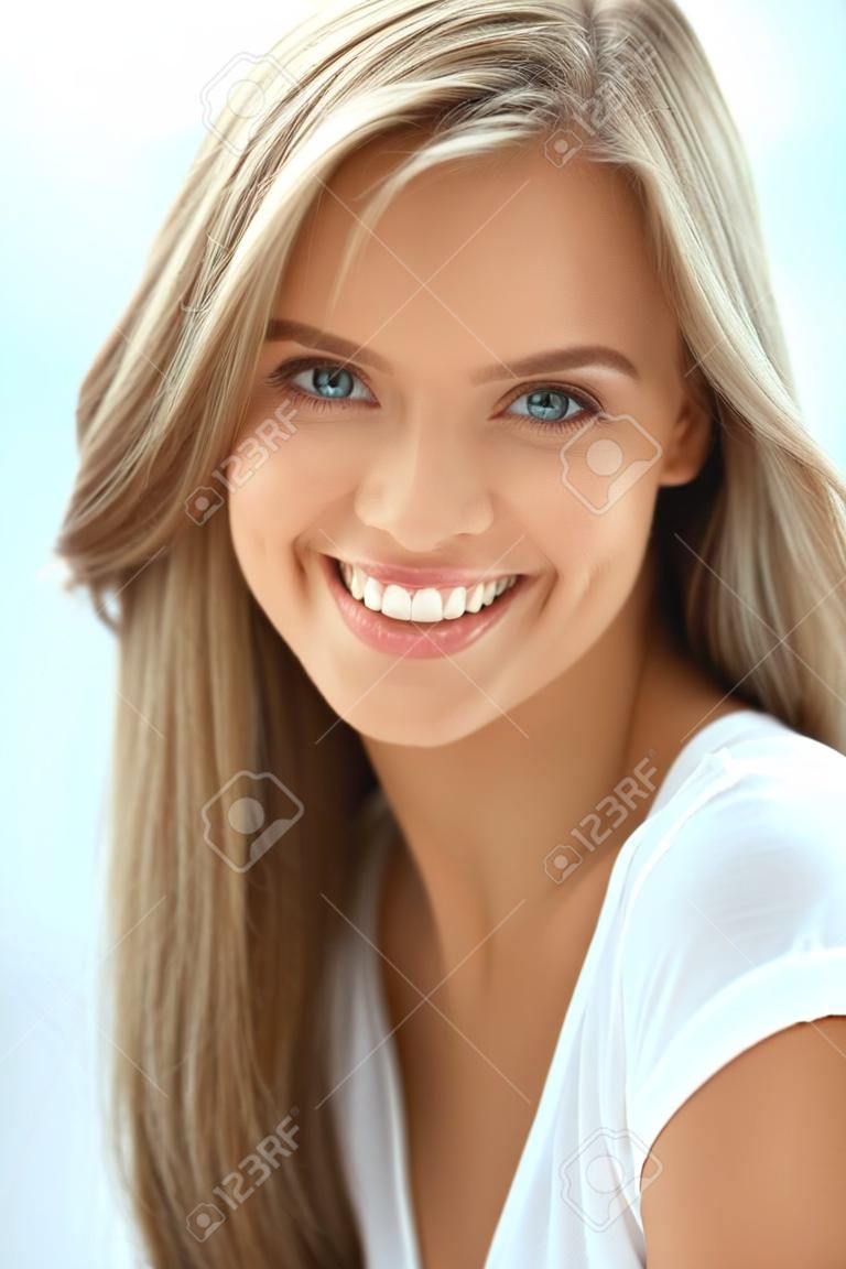 美しい女性の肖像画。完璧な笑顔、カメラで笑みを浮かべて白い歯と美しい幸せな女の子のクローズ アップ。新鮮な天然顔化粧室内で魅力的な健康的な若い女性。高解像度画像