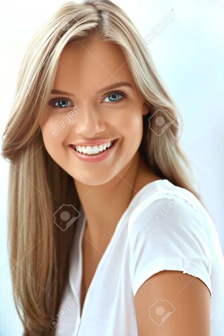 美しい女性の肖像画。完璧な笑顔、カメラで笑みを浮かべて白い歯と美しい幸せな女の子のクローズ アップ。新鮮な天然顔化粧室内で魅力的な健康的な若い女性。高解像度画像
