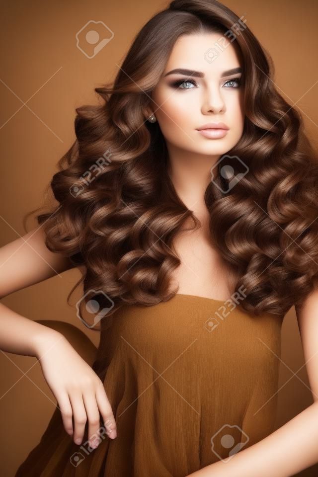 헤어 스타일. 건강한 긴 물결 모양의 곱슬 머리와 화려한 얼굴 메이크업 아름 다운 여자. 패션 헤어 스타일 갈색 머리 소녀 모델, 갈색 머리 색과 완벽한 곱슬 머리의 초상화입니다. 아름다움. 고품질