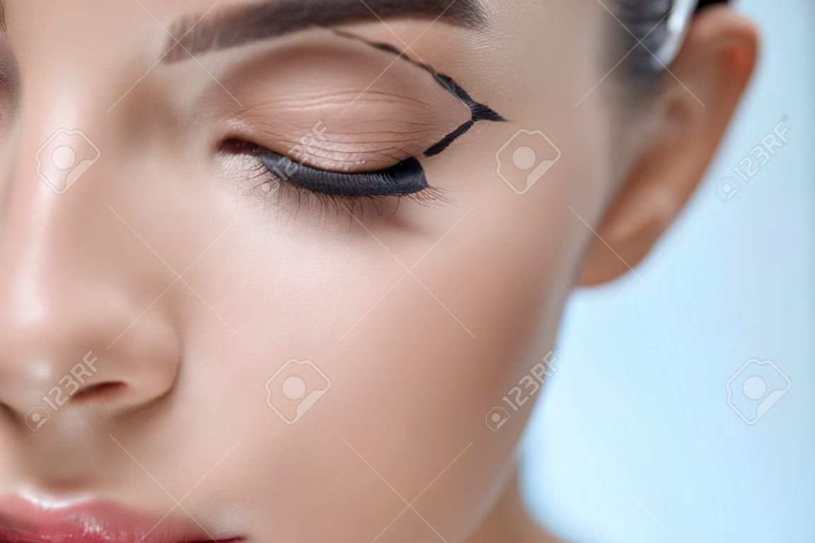 Plastic Surgery Operation. Closeup Beautiful Young Woman Face With Fresh Skin And Perfect Makeup On White Background. Female Face With Black Surgical Lines On Eyelids And Under Eyes. High Resolution