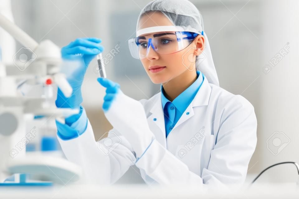 Laboratory. Woman Doing Medical Research With Blood. Portrait Of Beautiful Young Female In White Coat Sitting At Workplace And Working With Blood Sample In Lab. Medical Laboratory. High Resolution