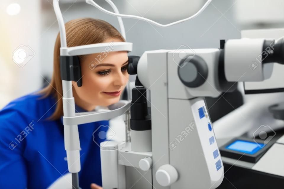 Badanie wzroku. kobieta sprawdzająca wzrok na sprzęcie optometrii