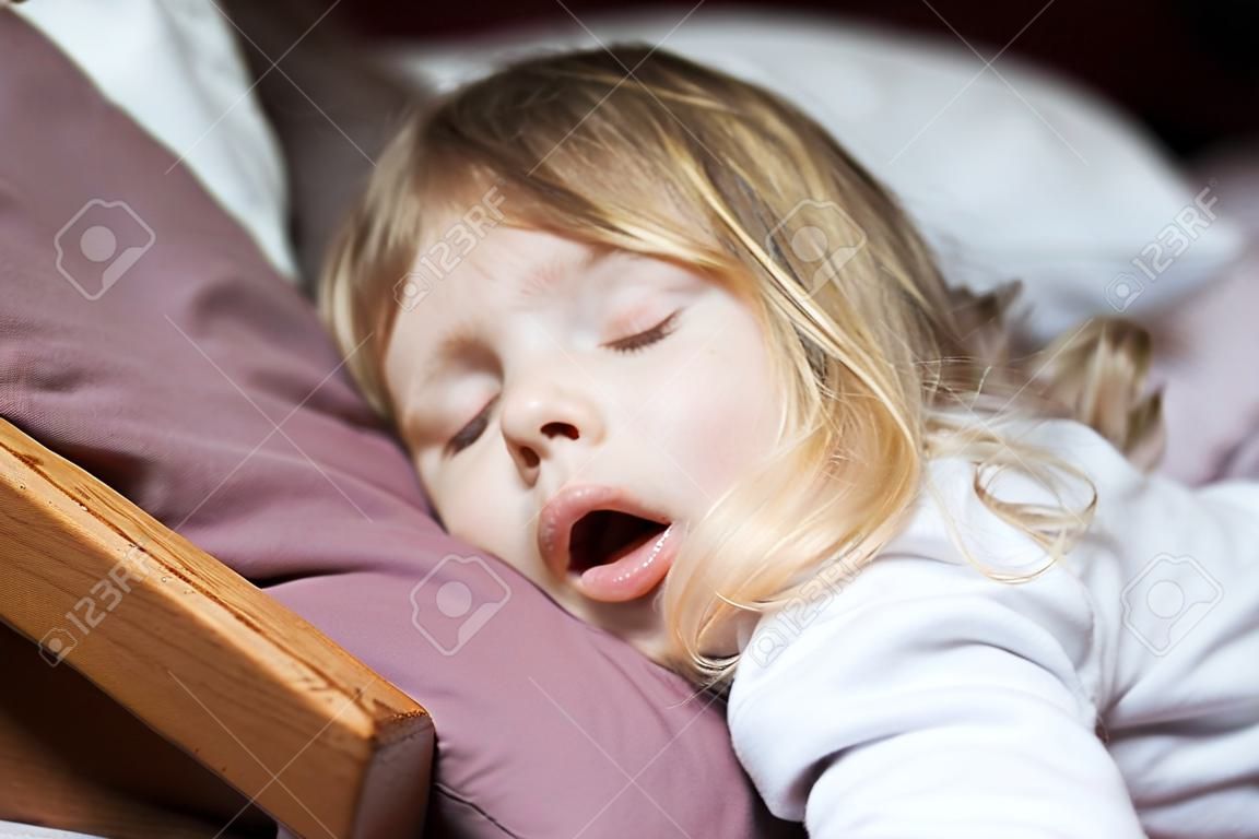 cara divertida expresión con la boca abierta de rubia caucásica niño de tres años de edad, durmiendo en cama king