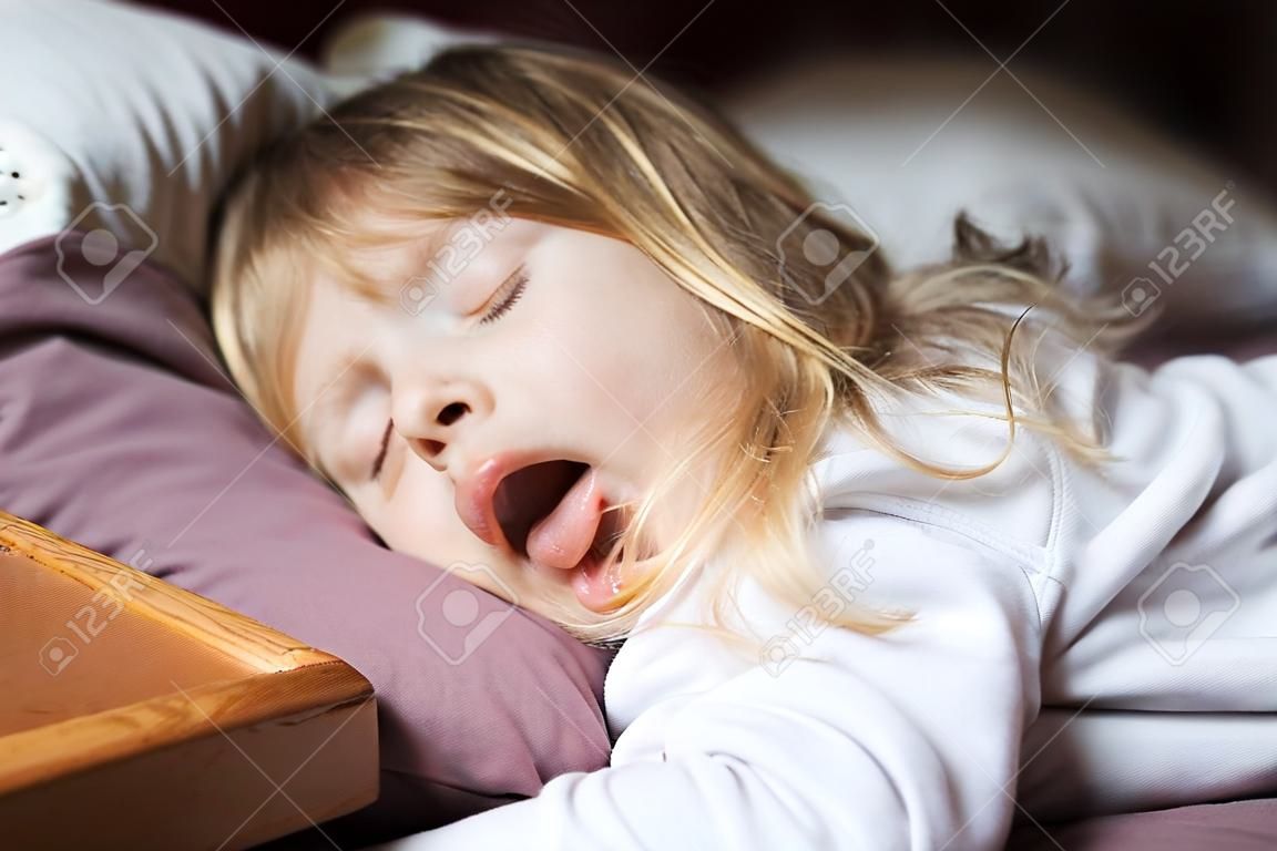 vicces arckifejezés nyílt szájban szőke kaukázusi három éves gyermek, alszik a king-ágy