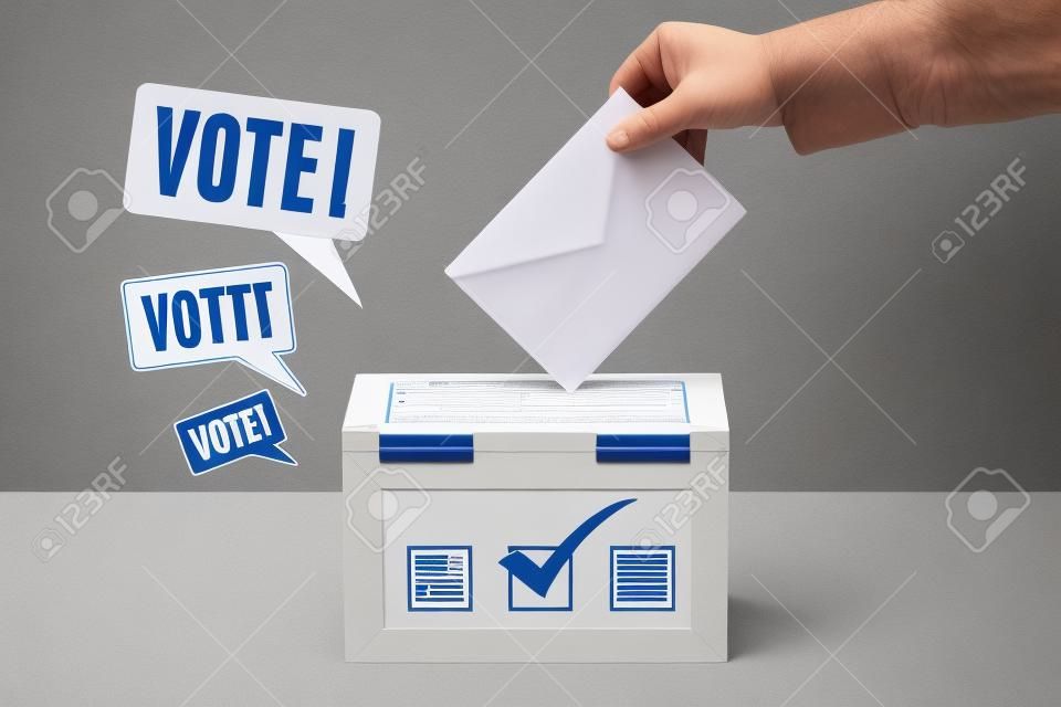 Una mano che mette una scheda di voto in un'urna elettorale
