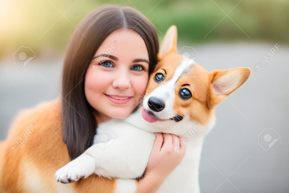 Menina e Corgi cão em casa close-up retrato. Jovem mulher sorrir e abraçar Welsh Corgi Pembroke. Estilo de vida com animal de estimação doméstico