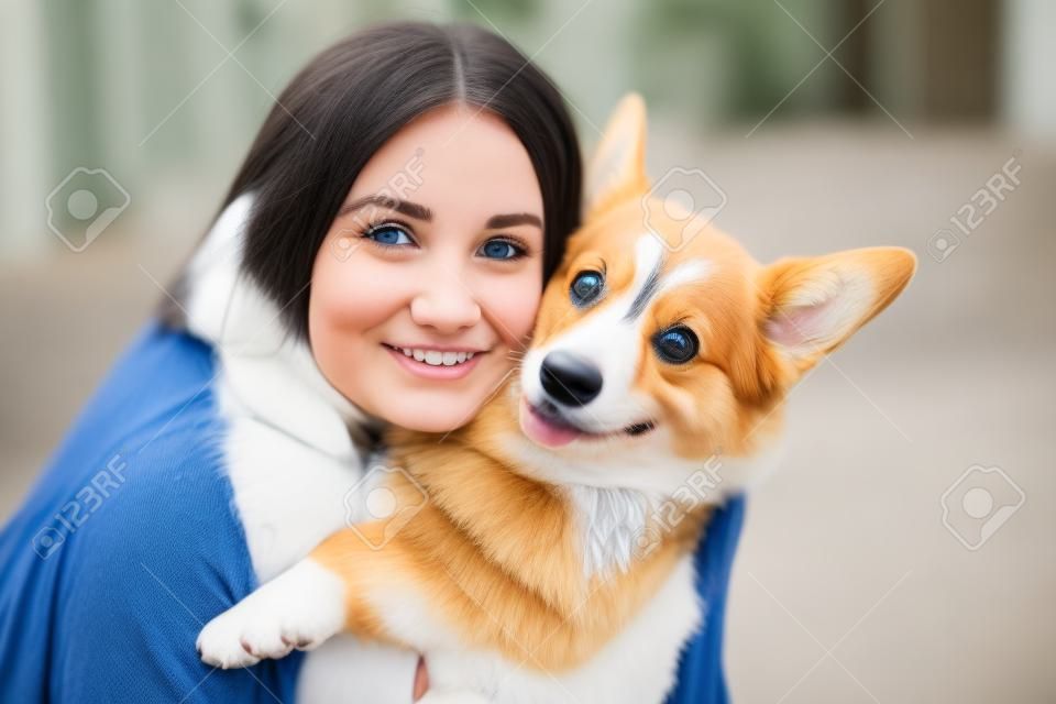 Menina e Corgi cão em casa close-up retrato. Jovem mulher sorrir e abraçar Welsh Corgi Pembroke. Estilo de vida com animal de estimação doméstico