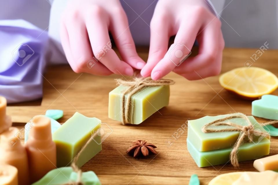 Woman is packing handmade natural soap as a gift for New Year and Christmas. Concept of preparing for holidays, hobbies, a cozy festive atmosphere.