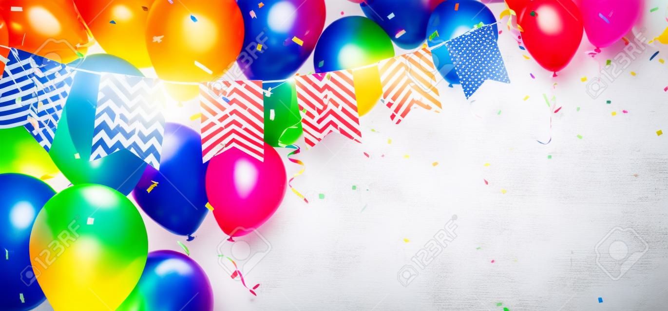 Ballon d'anniversaire coloré avec des drapeaux de banderoles et des confettis