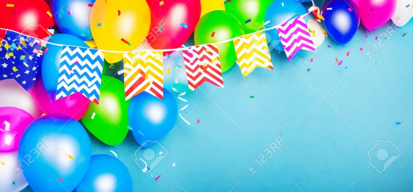 Ballon d'anniversaire coloré avec des drapeaux de banderoles et des confettis