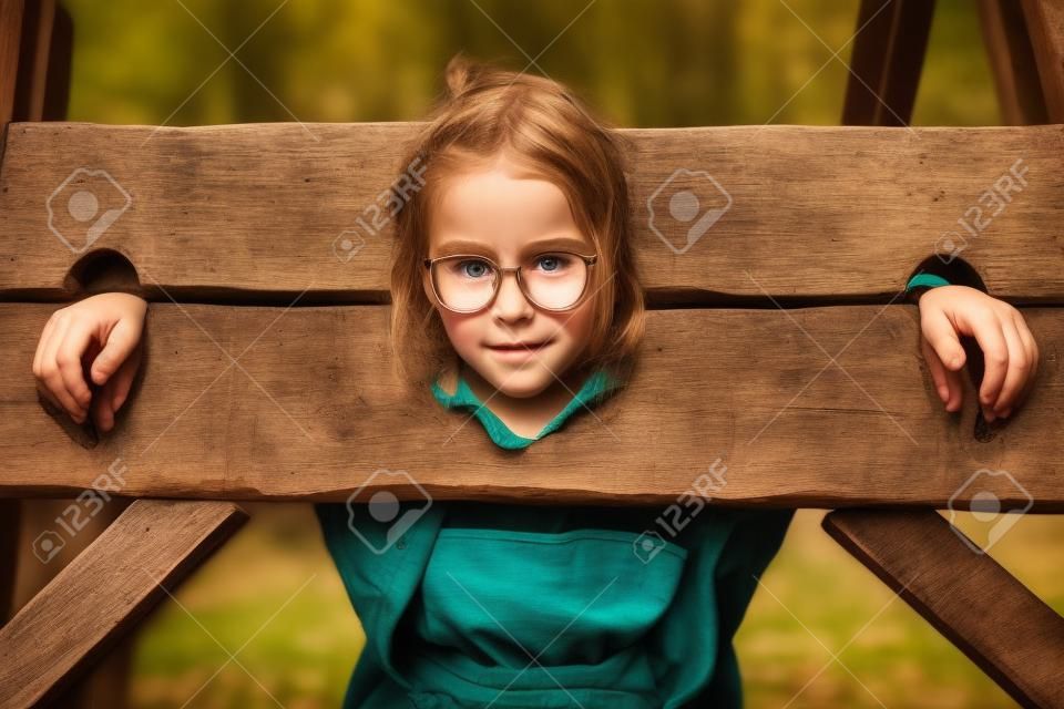 Portrait of girl in a wooden pillory