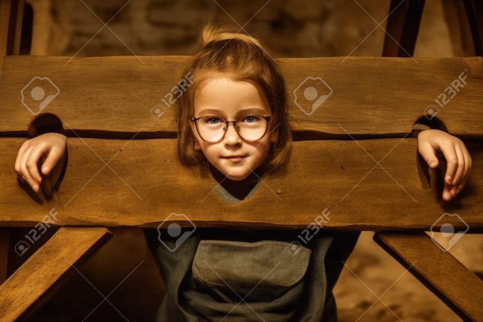Portrait of girl in a wooden pillory