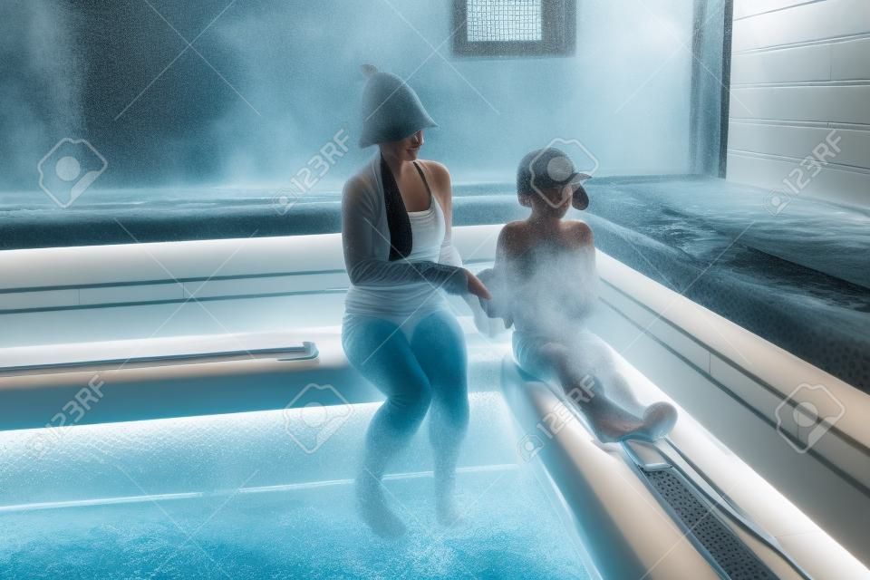 Mother and her son in steam room of Russian bath