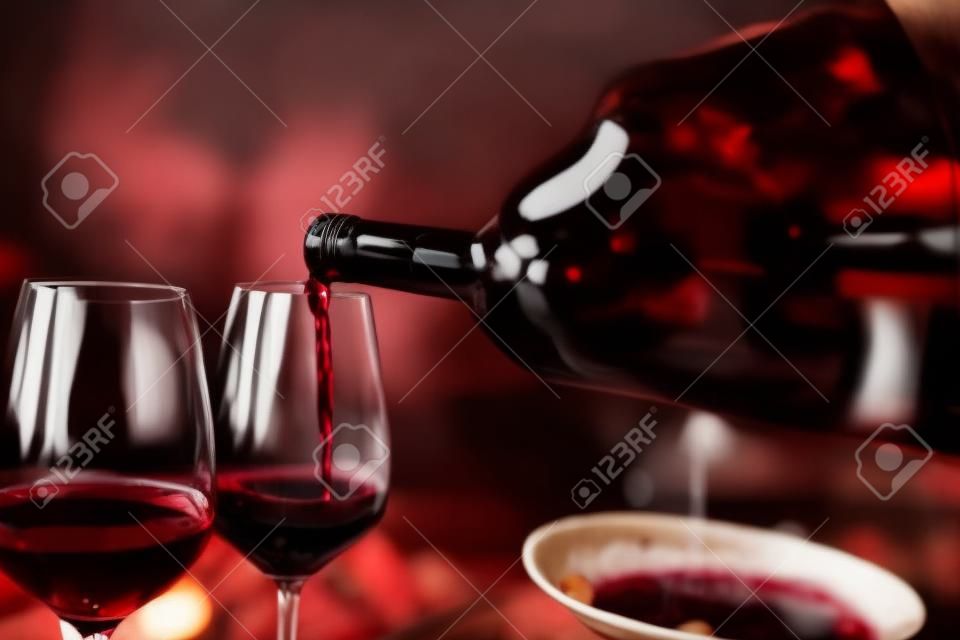 Persoon die rode wijn in een restaurant giet