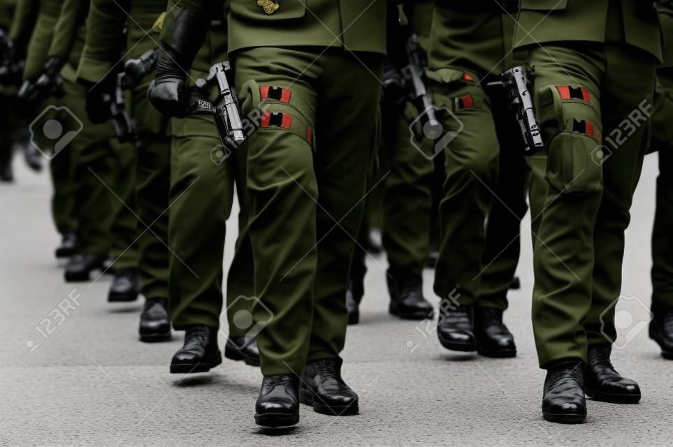 Soldado de mão em luva preta segurando uma pistola durante um desfile militar