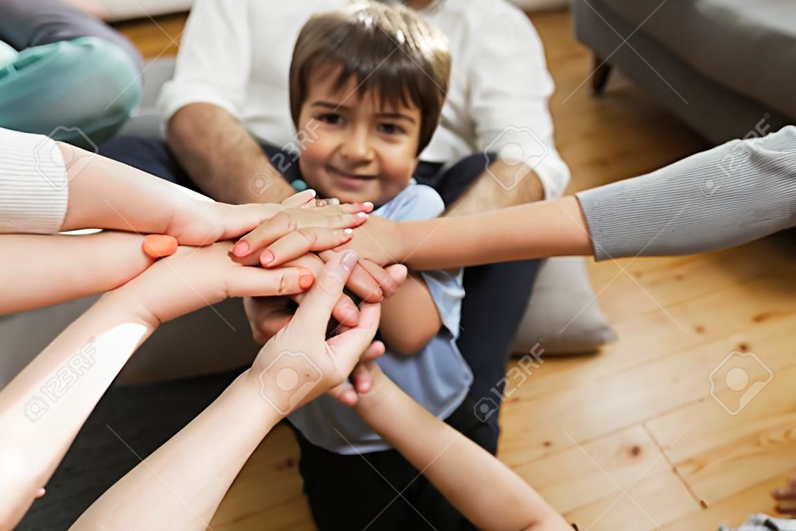 Portrait d'une famille heureuse avec les mains jointes. Concept d'une famille amusante et unie
