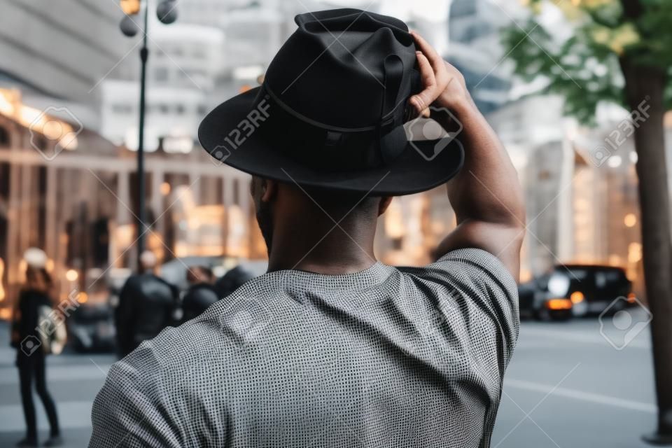 Ragazzo con cappello vestito con stile e moderno in città. Ragazzo nero