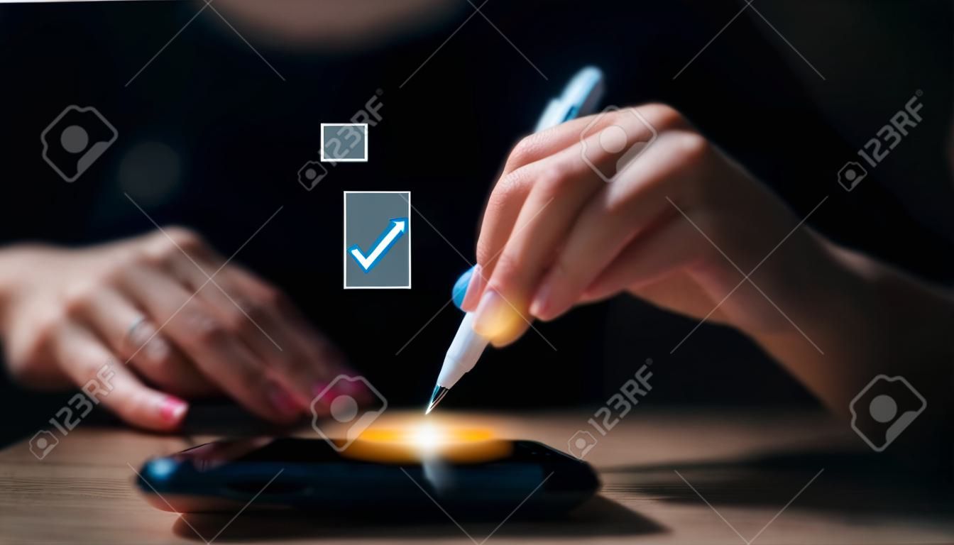 Las mujeres empresarias usan bolígrafos para marcar la marca correcta en la casilla de verificación de la lista de verificación de control de documentos de calidad y la empresa aprueba el concepto del proyecto