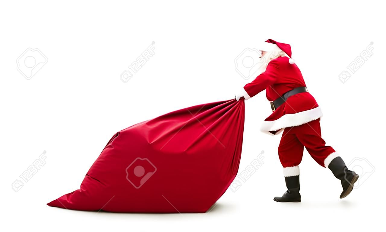 Santa Claus tirer grand sac plein de cadeaux de Noël isolé sur fond blanc