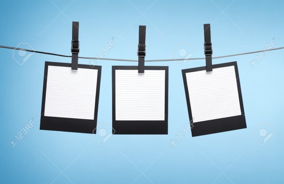 Blank photos hanging on a clothesline isolated on white background