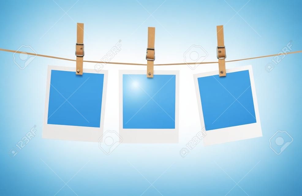 Blank photos hanging on a clothesline isolated on white background