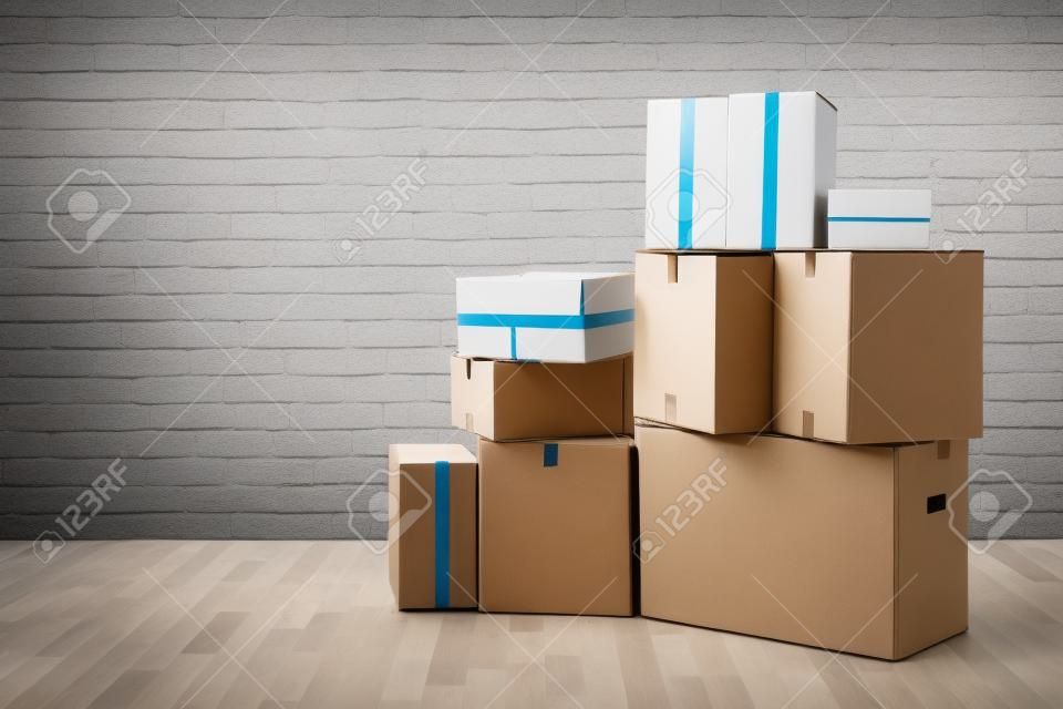 Emménager. Empiler des boîtes de carton dans la salle vide avec copie espace