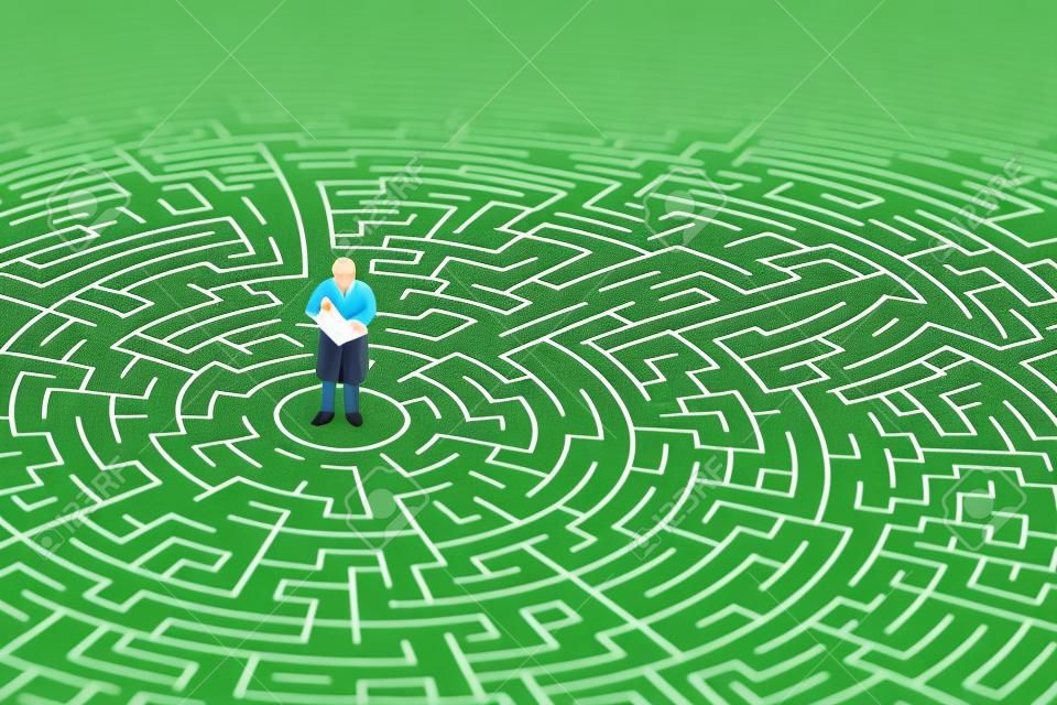 Miniaturleute: Geschäftsmann, der auf Mitte des Labyrinths liest. Konzepte zur Lösung, Problemlösung und Herausforderung.